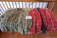 Two quilted flannel jackets, green and red plaid, laid on table with a note indicating 2 jackets.