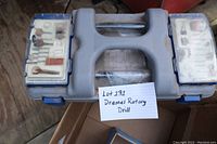 Closed plastic carrying case showing Dremel rotary drill kit with accessory compartments on the sides and central handle with label 'Lot 131 Dremel Rotary Drill'.