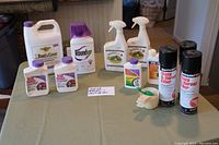 Full view of all garden and pesticide products arranged on a table showing bottles and spray cans.