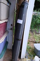 Full view of the black rubber pond liner roll standing upright.