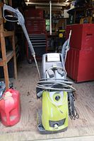Image showing a Sun Joe electric pressure washer with hose, wand, power cord, and a red plastic fuel container on the side.