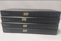 Four stacked Audio Access PX-4 multi-room remote control units showing front panels and worn labels.