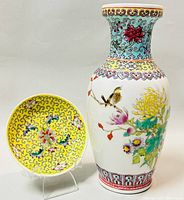 Vase and plate side by side showing color and detailed hand painted designs on both items.