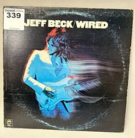 Front cover of Jeff Beck Wired vinyl record album showing musician in blue with guitar