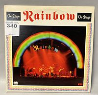 Front cover of Rainbow 'On Stage' double album with rainbow arc and stage photo.