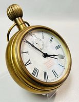 Close-up front angle showing brass clock case and dial with Roman numerals, subsidiary second dial, and Thomas & Ross branding
