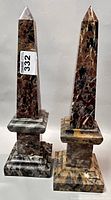 Pair of polished Italian marble obelisk bookends upright view, showing colors and shape.