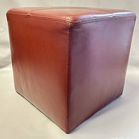 Front angled view showing cube shape and reddish-brown leather upholstery