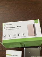 Photo of the GlocalMe U2S Global Portable Wi-Fi box displaying product features including 4G LTE, worldwide coverage, 5 connections, roaming free for 13 hours battery.