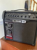 Close-up photo of front control panel and speaker with Line 6 branding and Spider Classic 15 label.