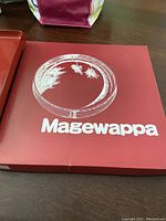 Clear round plate with etched pine and leaves design on red Magewappa box with logo