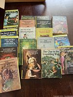 Photo showing 15 vintage Nancy Drew mystery books in good condition, arranged in two rows with colorful illustrated covers.