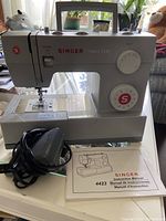 Singer 4423 sewing machine with manual and foot pedal cord shown on table
