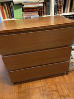 Photo of large wooden 3-drawer chest with flat drawer fronts and wood grain finish.
