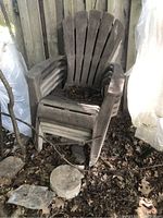 Photo of stacked plastic Muskoka style lawn chairs showing weathered and dirty condition with leaves and debris inside the seat area.