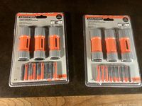 Two blister packs each containing three orange and gray LED flashlights with batteries included, all new and sealed in original packaging.