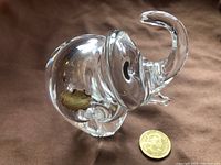 Clear close-up photo of the crystal elephant figurine showing the gold label on the side indicating it is handmade in Brazil.