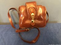 Front view of Marino vintage brown leather purse showing glossy finish and gold-tone clasp on flap.