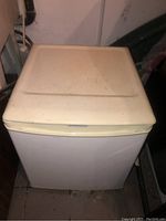 Top view of the white bar fridge showing scratches and discoloration on top surface.