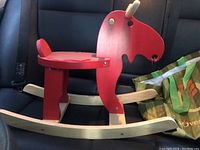 Red wooden rocking moose toddler toy with beige rockers, gently used, shown from side angle.