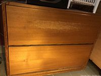 Front view of wooden legal file cabinet showing two large drawers with worn finish and discoloration.