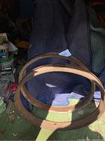 Two rusty metal wheel rims placed on moving blankets. Clearly 24-inch diameter rims with some rust and dirt. Likely for early Ford Model T or Model A vehicles.