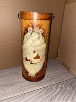 Photo of tall wooden stein with hand-painted winter scene and floral decorations, showing front side with church and snowy landscape artwork