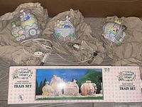 Photo showing the three lighted porcelain train pieces and the original box displaying the set in assembled form.