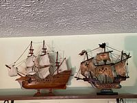 Both vintage model ships on shelf showing Pinta and Mayflower with sails and rigging