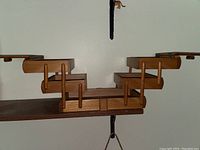 Full view of vintage wooden sewing box with both sides fully extended, showing the multi-arm hinges and compartment layout.