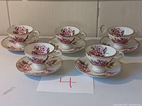 Five demitasse cups and matching saucers set, hand painted with floral pattern and gold trim