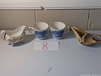 Full view of all four items: two tea cups and two creamers.