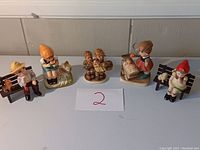Six vintage knickknacks including children figurines arranged in a row showing the full lot