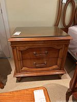 Front view of one Pepplers wood end table showing wood details and glass top.