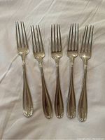 Five 7-inch forks arranged side by side showing tines and handles