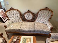 Front view of sofa showing full carved wood frame and upholstered cushions