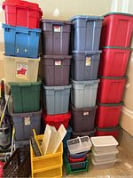 Photo of various stacked plastic bins in red, blue, gray, brown, green, and clear with lids, alongside smaller plastic baskets in assorted colors and styles.