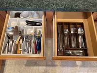 Photo of two kitchen drawers showing assorted cutlery and utensils including spoons, forks, peelers, and small kitchen tools.
