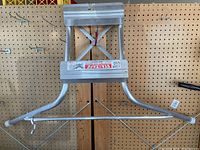 Front view of the metal ladder stabilizer showing curved arms and cross-bracing.