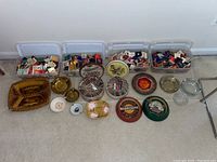Wide shot of three plastic bins filled with matchbooks, assorted ashtrays displayed in front