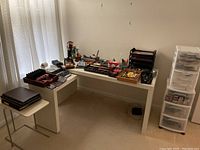 Side table with assorted office supplies and multi-drawer plastic organizer on the right