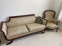 Sofa and high back chair side by side showing upholstery and wood frame