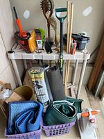 Photo showing assorted yard tools including hedge trimmer, plastic sheeting, hand tools, weed block and tarps
