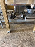 Photo of stacked metal baking trays, grill trays, and other rectangular pans showing quantity and sizes.