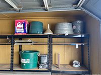 Shelf with various buckets, a funnel, and the heater burner seen on the right side.