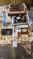 Overview of the lot showing picture frames, calculator, letter opener and various collectibles spread on a table.