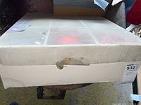 Original box of outdoor ornaments with a closing flap and label showing lot number 532.