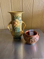 Both Roseville pottery vase and bowl placed side by side on a surface, showing size and color contrast.