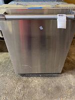 Front view of Thunder dishwasher showing stainless steel front and handle along with auction label attached.
