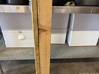 Three white plastic storage bins seen on metal shelf, each is a large bin with lid.